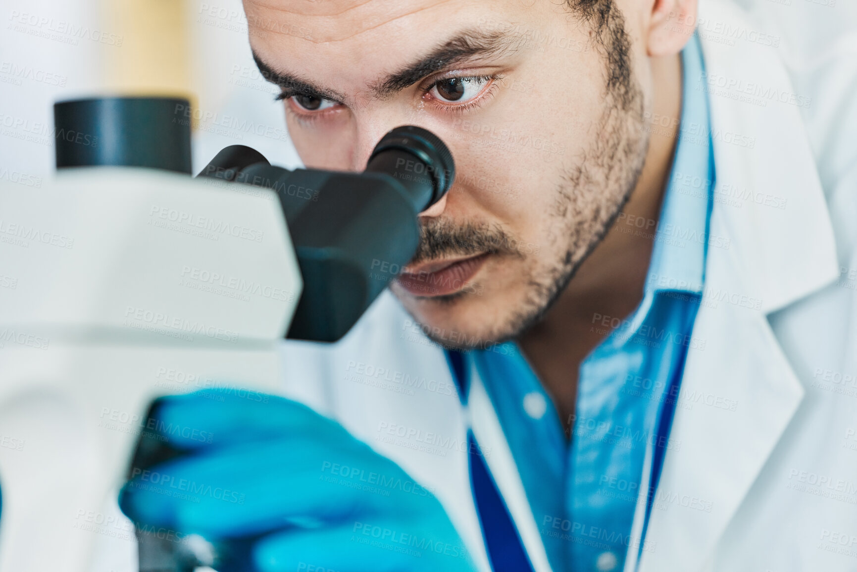 Buy stock photo Shot of a young scientist using a microscope in a lab