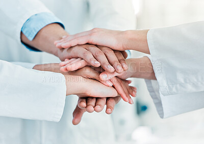 Buy stock photo Closeup shot of a group of unrecognisable scientists joining their hands together in a huddle in a lab
