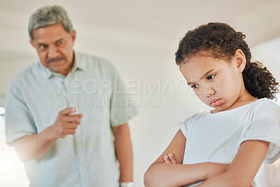 Buy stock photo Shot of a mature man looking annoyed with his granddaughter at home