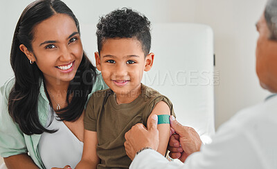 Buy stock photo Shot of a mature male doctor applying a bandaid to a little boy's arm at a hospital