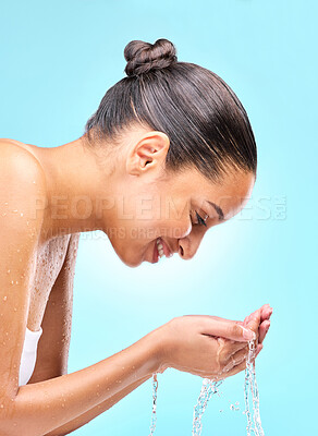 Buy stock photo Woman, water on hands and happy with face, skincare and hygiene for wellness and shower routine. Closeup, stream splash and washing for healthy hydration, smile by studio blue background and cleaning