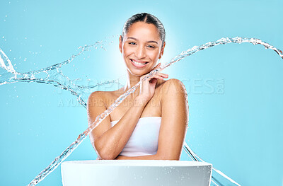 Buy stock photo Portrait, woman and happy model with water, skincare and hygiene for wellness and routine by basin. Face, stream splash and washing for health hydration, smile by studio blue background and cleaning