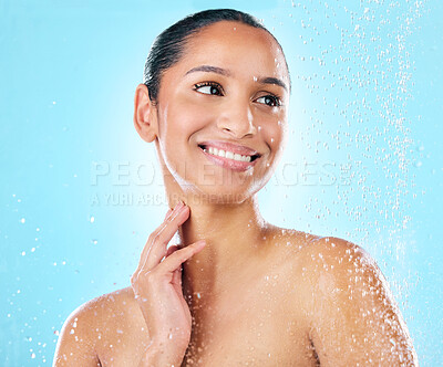 Buy stock photo Shot of a beautiful young woman taking a shower against a blue background