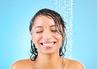 Buy stock photo Shot of a beautiful young woman taking a shower against a blue background