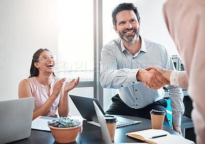 Buy stock photo Shot of a mature businessman shaking hands with a colleague during a meeting in the office