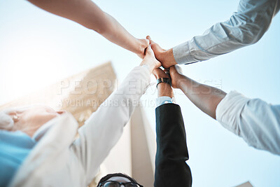 Buy stock photo Low angle shot of an unrecognisable group of businesspeople standing outside together and raising her hands