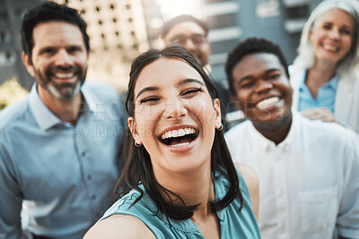 Buy stock photo Shot of an attractive young businesswoman standing outside with her colleagues and taking selfies