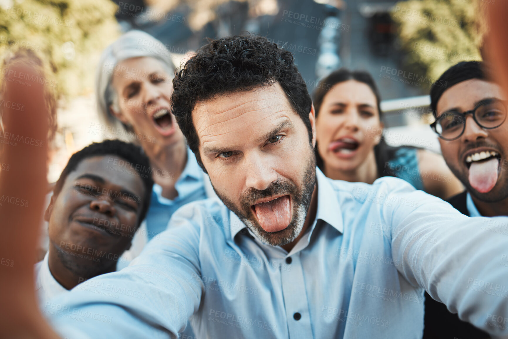 Buy stock photo Shot of a mature businessman standing outside with his colleagues and taking selfies