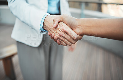Buy stock photo Cropped shot of two unrecognisable businesspeople standing outside together and shaking hands