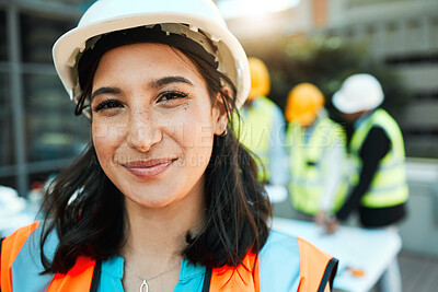 Buy stock photo Shot of an attractive young contractor standing outside while her colleagues work behind her