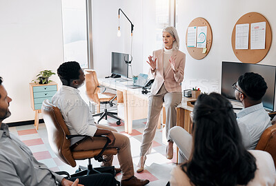 Buy stock photo Shot of a mature businesswoman sitting and training her team in the office