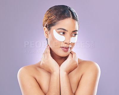 Buy stock photo Shot of a young woman using eye masks against a pink background