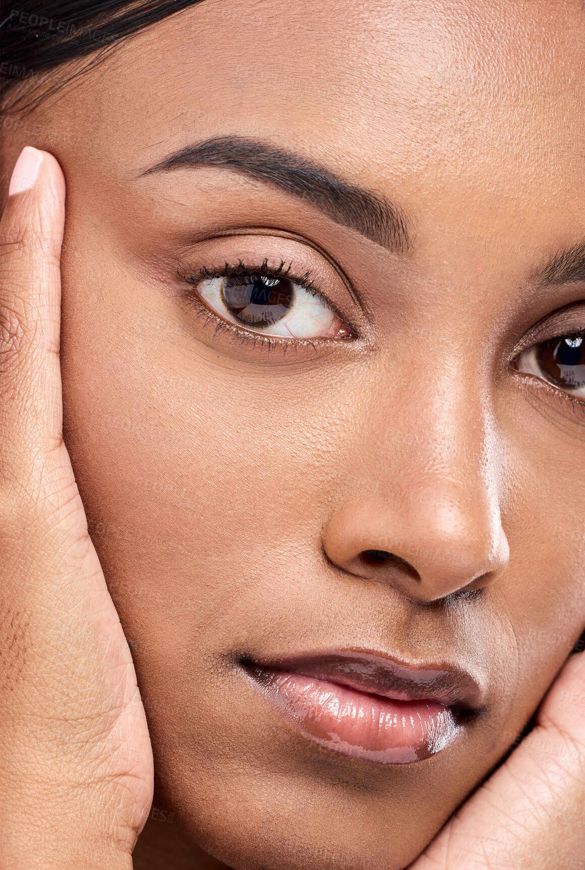 Buy stock photo Closeup portrait of an attractive young woman posing with her hands on her face in studio