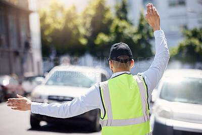 Buy stock photo Rearview shot of a traffic warden guiding vehicles outdoors