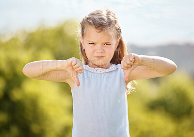 Buy stock photo Portrait, thumbs down and child in park, girl and protest with gesture, annoyed and frustrated in nature. Dislike, opinion and kid with sign, rejection and emotion for review, unhappy and Canada