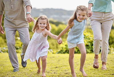 Buy stock photo Shot of a couple and their two daughters posing together in a park