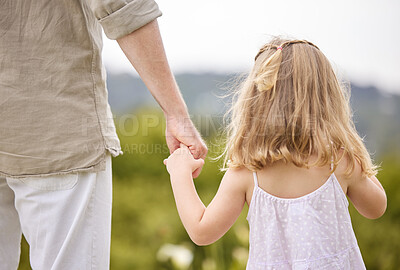 Buy stock photo Shot of a man holding his daughter's hand while walking outside