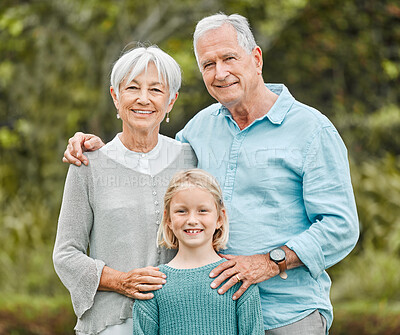 Buy stock photo Shot of a senior couple standing outside with their granddaughter