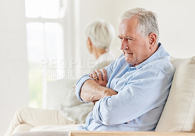 Buy stock photo Shot of a mature couple looking annoyed after a disagreement on the sofa at home