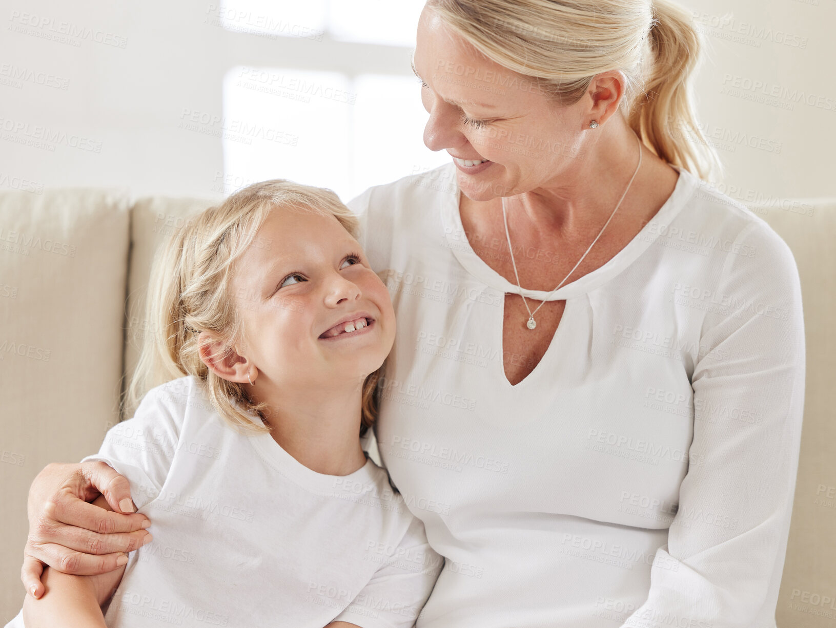 Buy stock photo Mother, daughter and hug in home for protection, love and support child in relationship on couch. Mama, girl and embrace kid for trust on weekend, family house and connection for care in living room