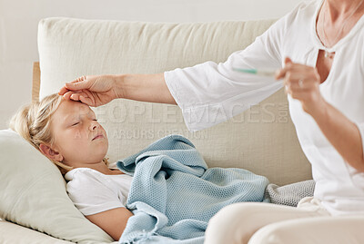 Buy stock photo Shot of a mother checking her daughters temperature on the sofa at home