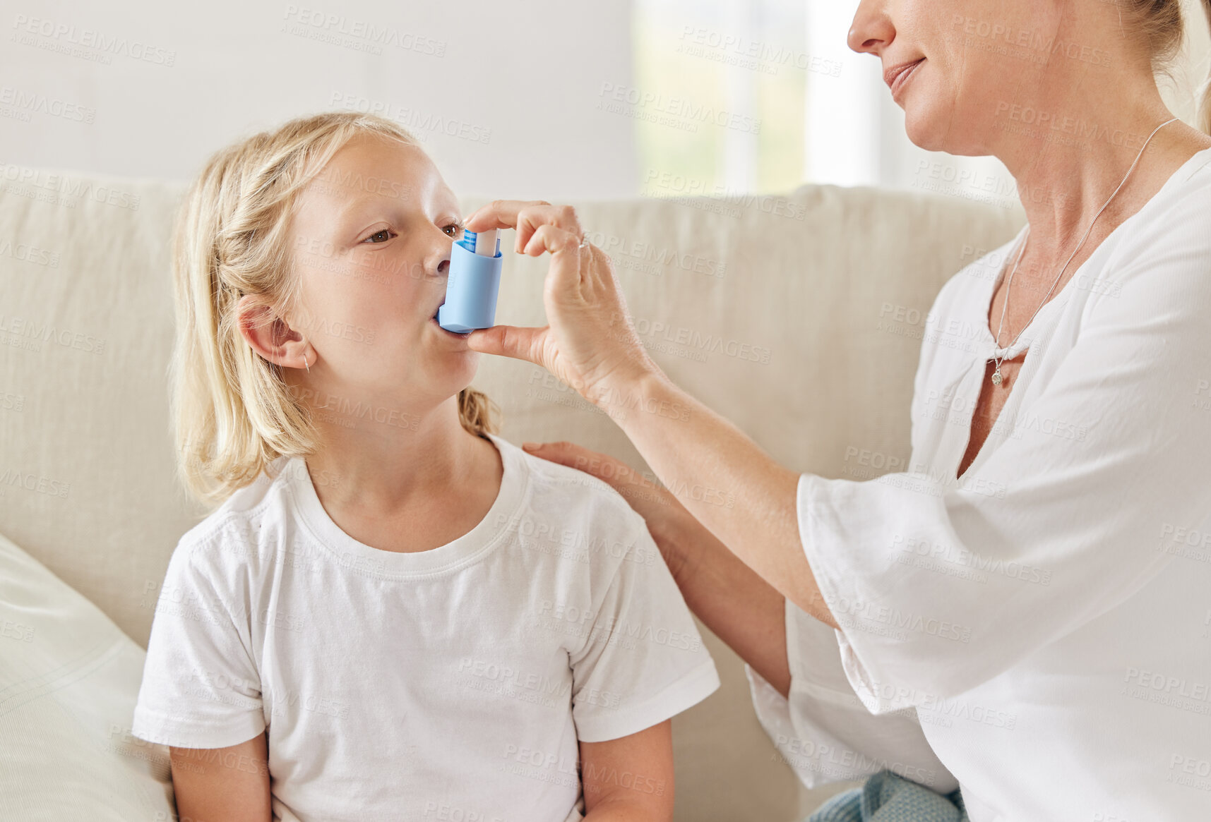 Buy stock photo Mother, girl and inhaler for symptoms, breathing and illness in living room for relief or care in house. Woman, child and sick in home with asthma pump, prescription and wellness as medical condition