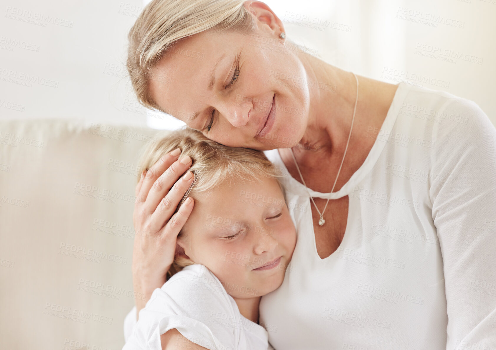 Buy stock photo Mother, daughter and hug in home for security, love and support child in relationship on couch. Mama, girl and embrace kid for trust on weekend, family house and care with eyes closed in living room