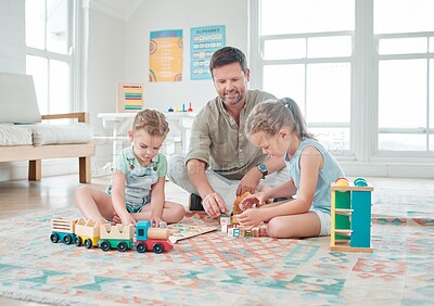 Buy stock photo Shot of a father sitting with his two daughters while they play with their toys