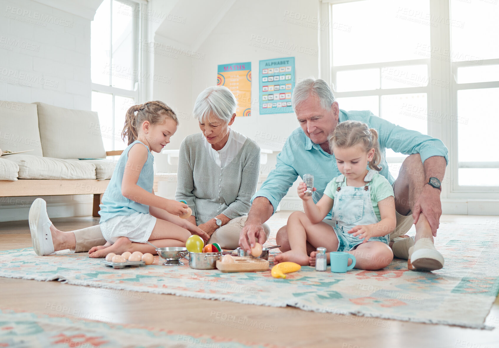 Buy stock photo Shot of two little girls playing with their toys while sitting at home with their grandparents