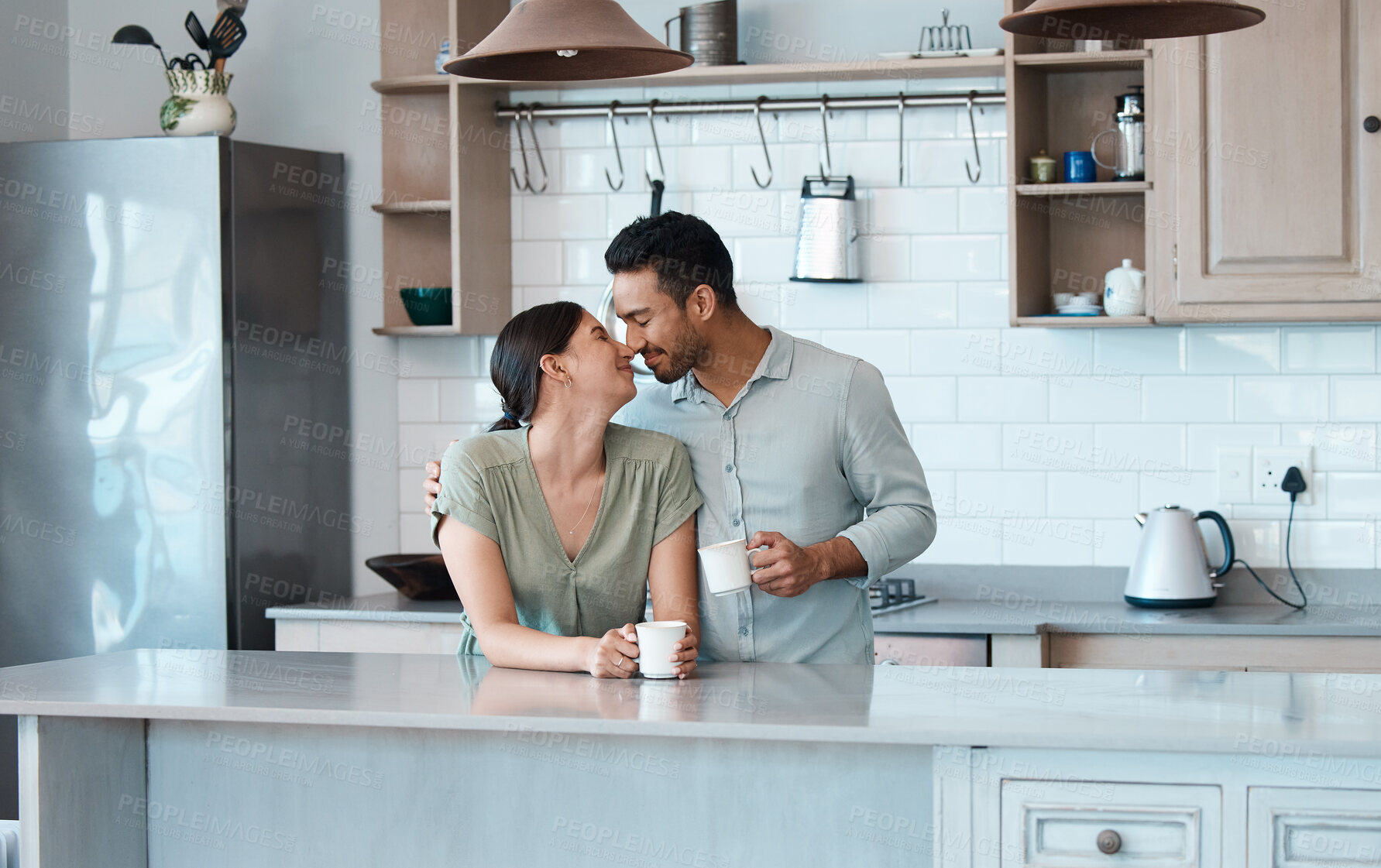 Buy stock photo Shot of a young couple having a cup of coffee together at home