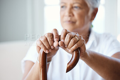 Buy stock photo Closeup shot of a senior woman holding her cane while sitting in the old age home