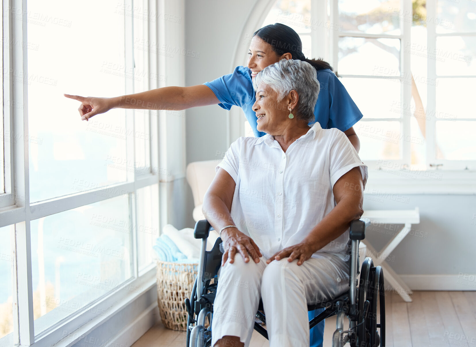 Buy stock photo Nurse, woman with a disability and pointing for wheelchair, healthcare and support with assisted living. Patient, caregiver and happy for home service, retirement and rehabilitation for senior care