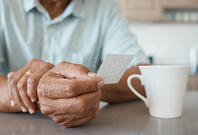 Buy stock photo Shot of an unrecognizable person holding a photo while drinking coffee at home