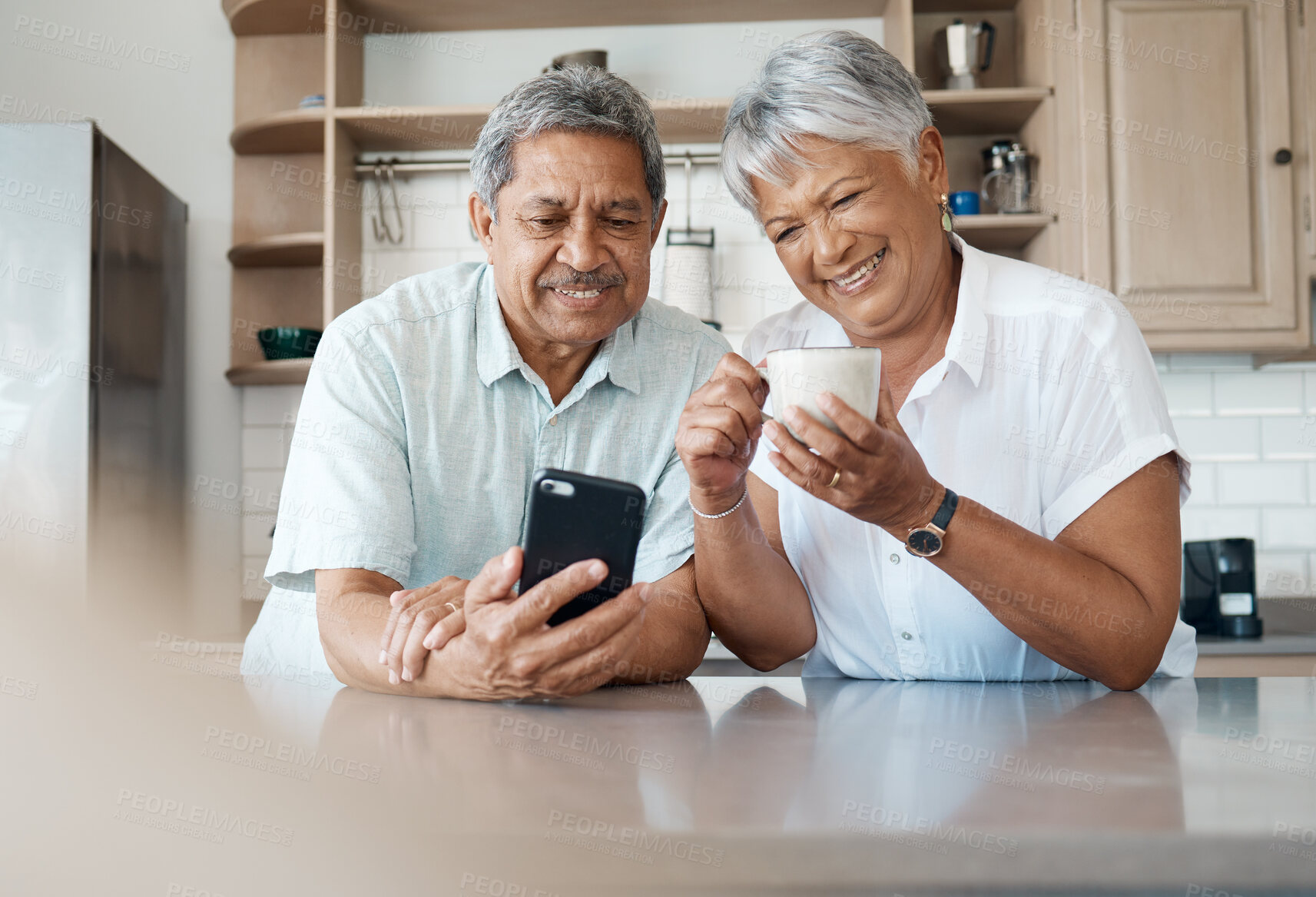 Buy stock photo Shot of a senior couple using a phone together at home