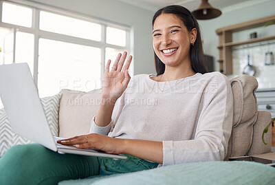 Buy stock photo Shot of a woman waving while using her laptop on the couch at home