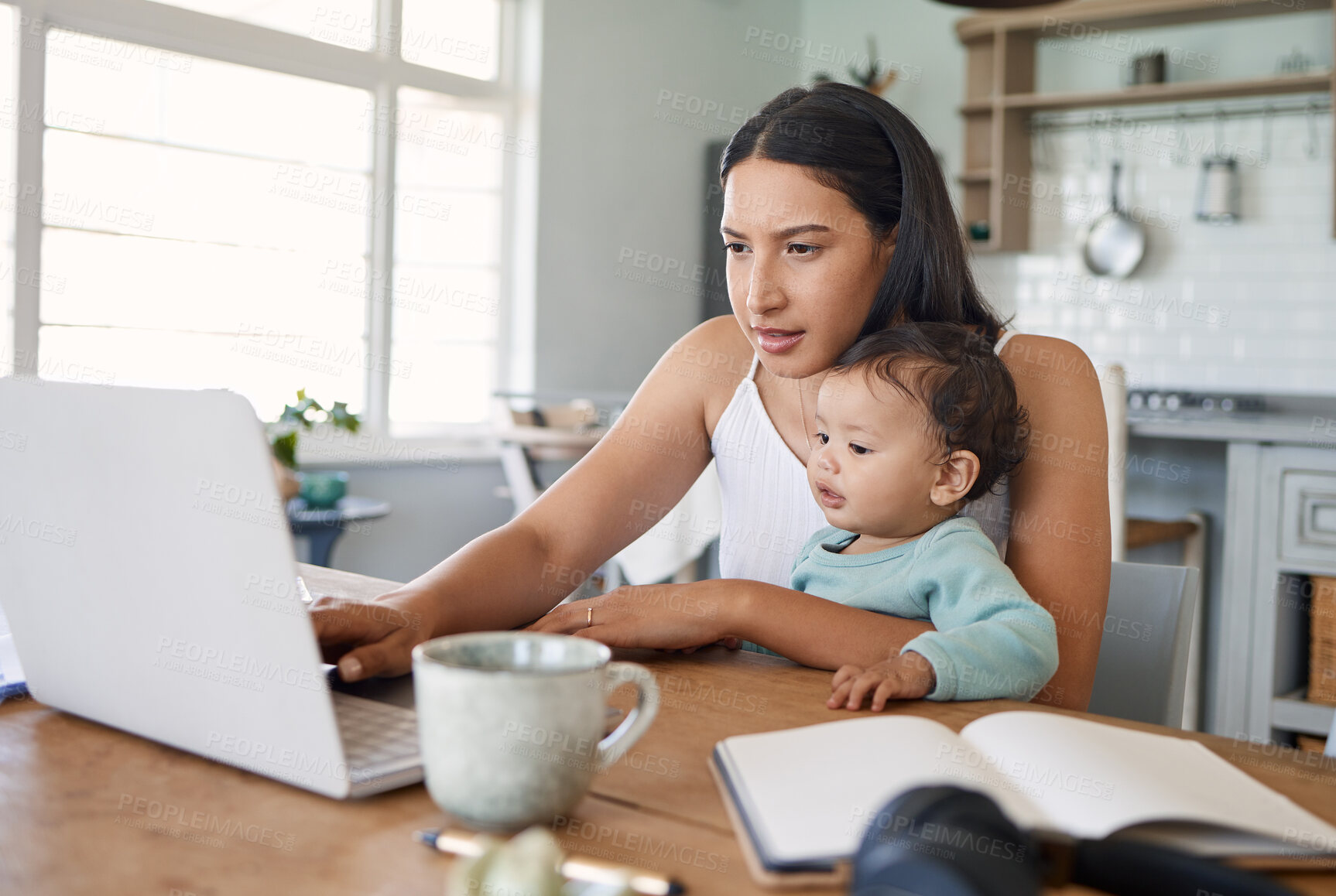 Buy stock photo Shot of a mom working on her laptop with her baby on her lap