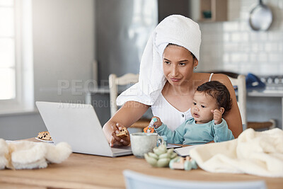 Buy stock photo Shot of a woman eating rusks while working on her laptop and holding her baby on her lap
