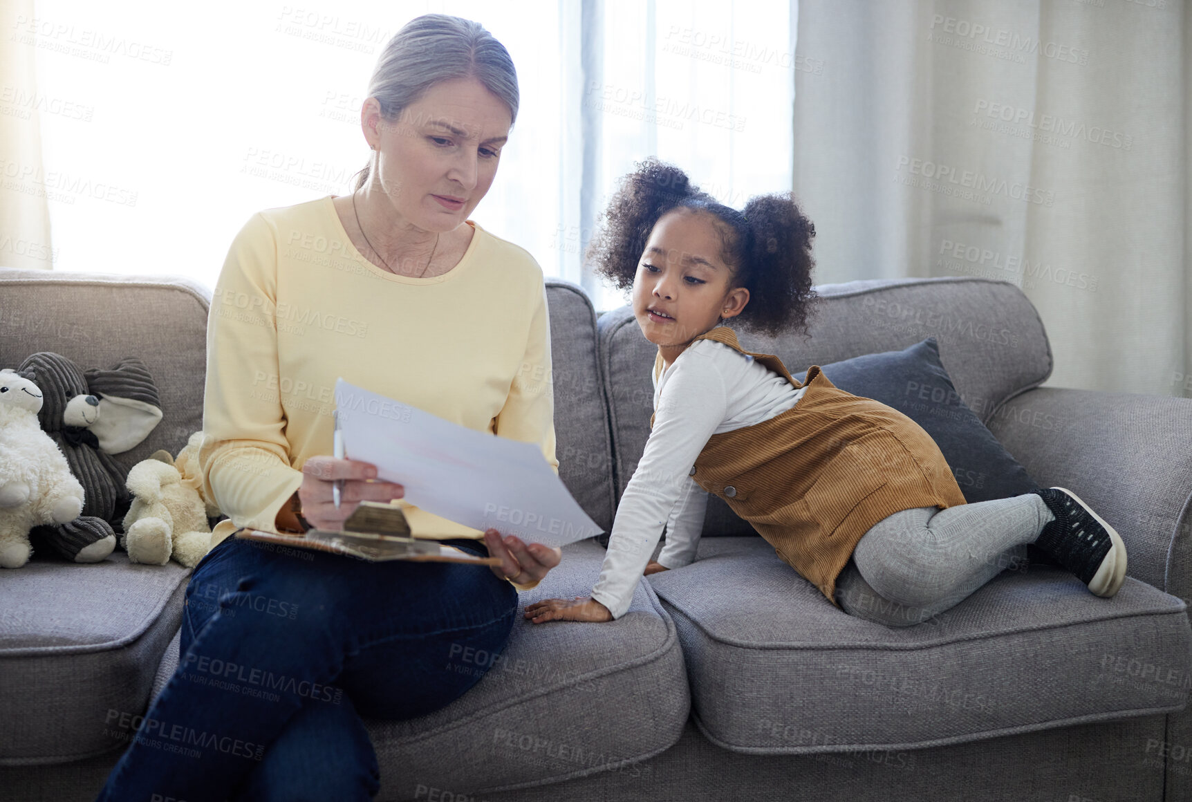 Buy stock photo Shot of a mature therapist looking at drawing that her patient completed