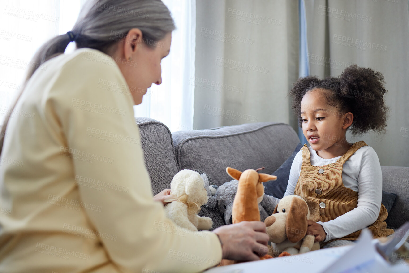 Buy stock photo Psychologist, kid and teddy bear in office for therapy, ADHD assessment and notes on sofa. Mature therapist, girl and stuffed animals in practice for evaluation, sensory development and psychology