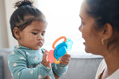 Buy stock photo Shot of an adorable little girl playing with a toy while bonding with her mother