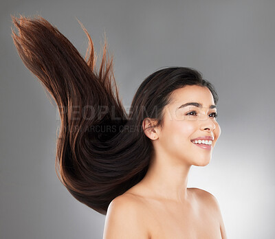 Buy stock photo Studio shot of a beautiful young woman with flowing hair against a grey background