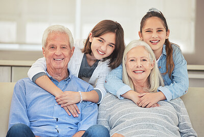 Buy stock photo Shot of a mature couple bonding with their grandkids on a sofa at home