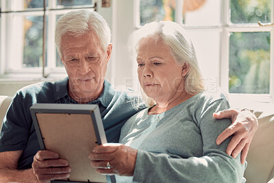 Buy stock photo Senior couple, sad memory and photo frame for nostalgia, history or remember past together in home. Retirement, man and woman hold picture for reminder of loss, grief or missing person in living room