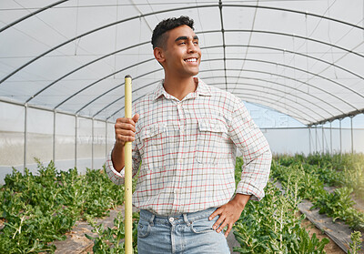 Buy stock photo Shot of a young man using a gardening tool while working in a greenhouse on a farm