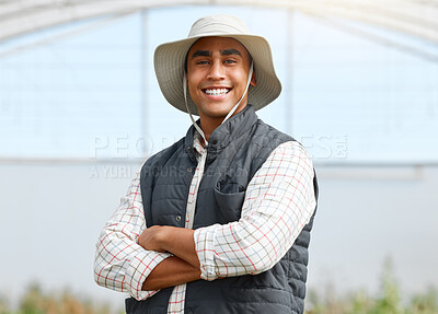 Buy stock photo Portrait of a young man standing with his arms crossed while working on a farm