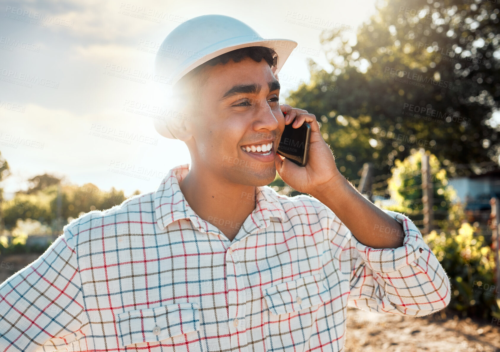 Buy stock photo Shot of a young man talking on a cellphone while working on a farm