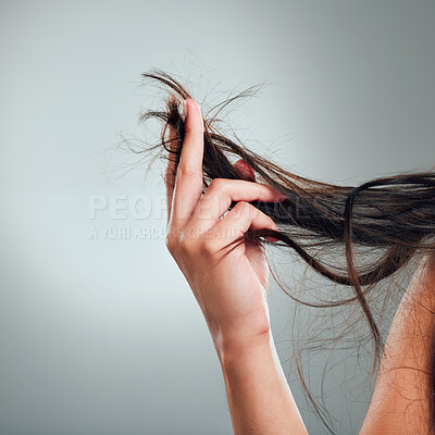 Buy stock photo Cropped shot of an unrecognizable woman holding up her damaged hair