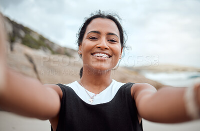 Buy stock photo Shot of a young woman taking a selfie on the beach