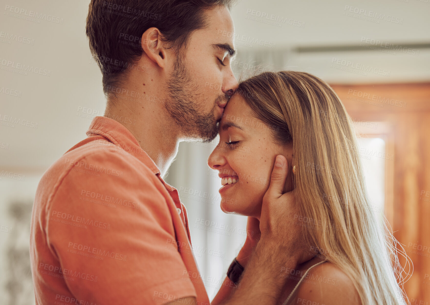 Buy stock photo Happy, kiss forehead and couple in home for bonding, relationship and commitment together in morning. Dating, marriage and man and woman embrace for affection, trust or romantic moment in living room