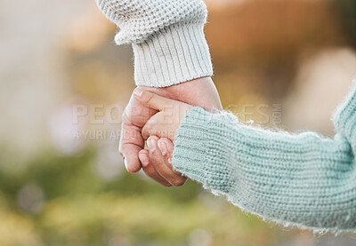 Buy stock photo Shot of a man holding his daughter's hand while walking outside